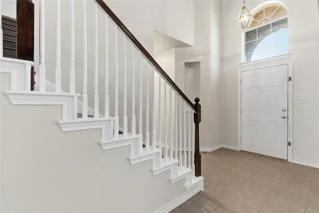 a view of staircase with railing and white walls