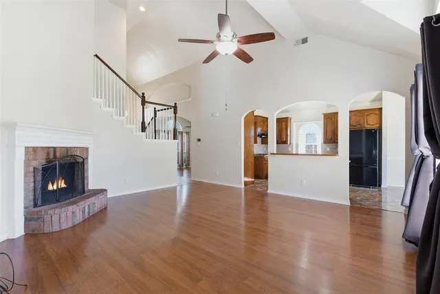 a view of a livingroom with wooden floor and a fireplace