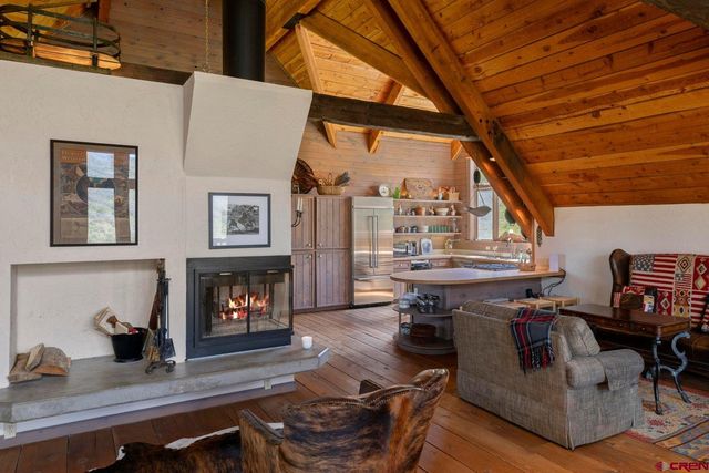 a living room with furniture a fireplace and a floor to ceiling window