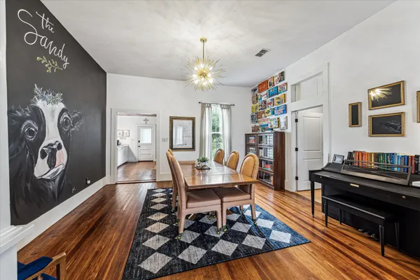 a living room with furniture piano and a chandelier
