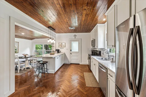 a large white kitchen with lots of counter top space and stainless steel appliances
