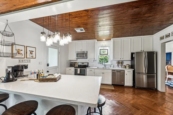 a kitchen with stainless steel appliances granite countertop a sink refrigerator and cabinets