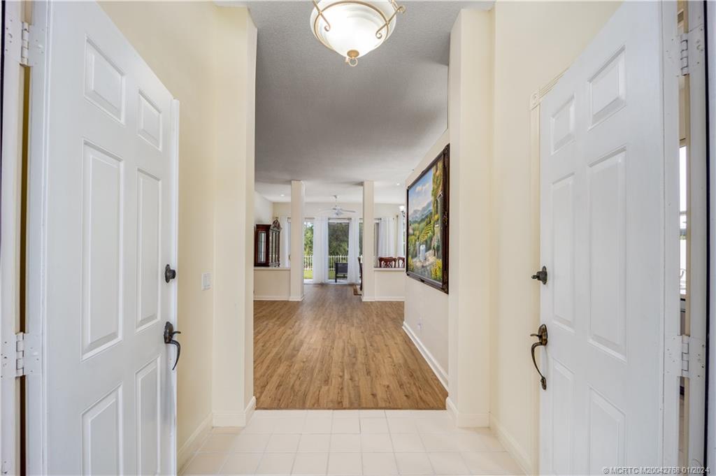 7199 Southeast Bitterroot Circle Hobe Sound, FL 33455 - Photo 11 of 28 a view of a hallway with wooden floor and staircase