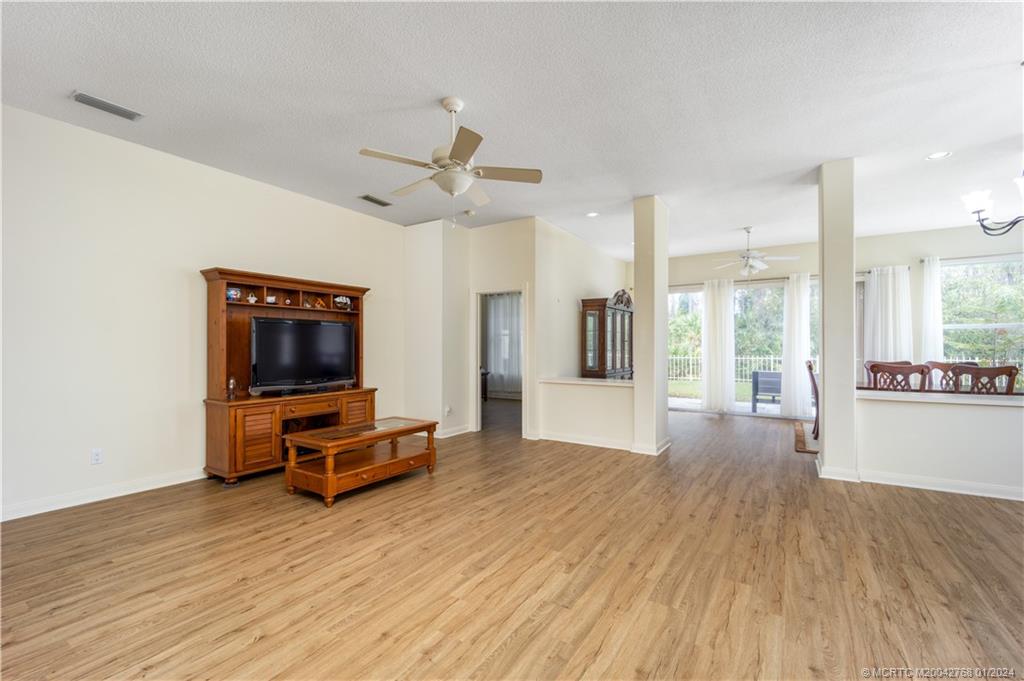 7199 Southeast Bitterroot Circle Hobe Sound, FL 33455 - Photo 12 of 28 a view of a livingroom with furniture a flat screen tv and wooden floor