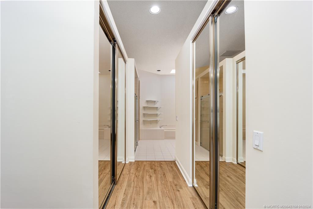 7199 Southeast Bitterroot Circle Hobe Sound, FL 33455 - Photo 18 of 28 a view of a hallway with wooden floor and staircase