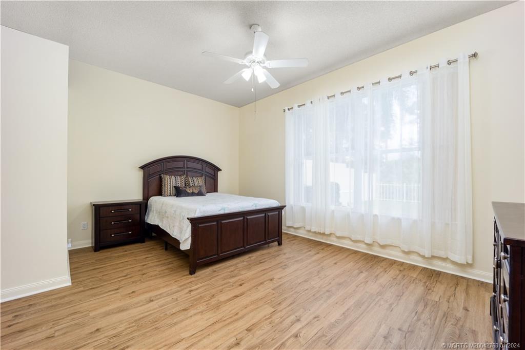 7199 Southeast Bitterroot Circle Hobe Sound, FL 33455 - Photo 21 of 28 a bedroom with a bed and a window