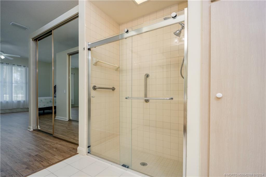 7199 Southeast Bitterroot Circle Hobe Sound, FL 33455 - Photo 22 of 28 a bathroom with a shower and a glass door