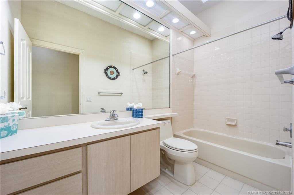 7199 Southeast Bitterroot Circle Hobe Sound, FL 33455 - Photo 25 of 28 a bathroom with a sink a toilet and a mirror