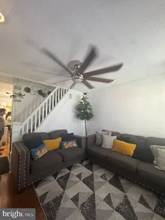 a living room with furniture and stairs