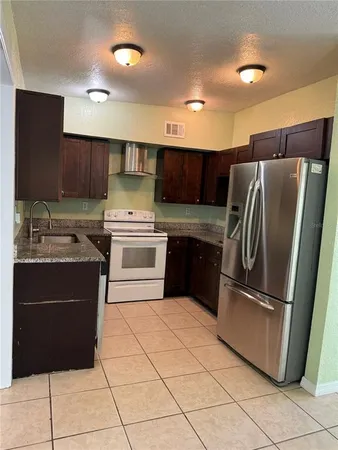 a kitchen with stainless steel appliances granite countertop a refrigerator sink and cabinets
