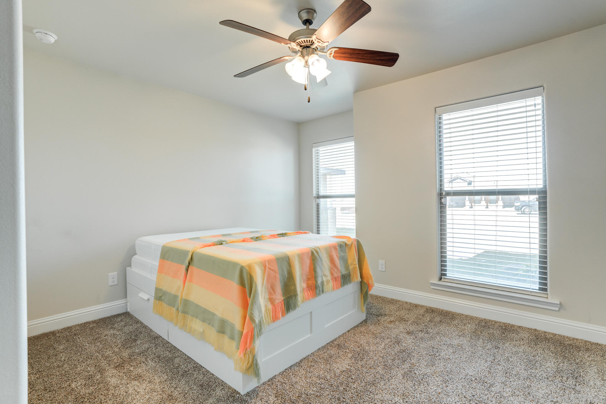 7535 103rd Street Lubbock, TX 79424 - Photo 32 of 35 a bed sitting in a bedroom next to a window
