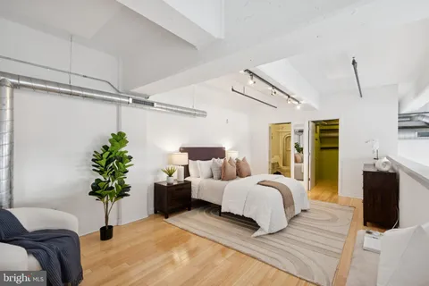 a bedroom with a bed and a potted plant