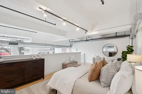 a bedroom with a bed and a large mirror on the dresser