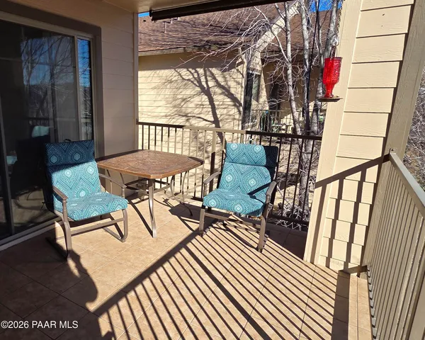 a view of a patio with table and chairs with wooden floor and fence
