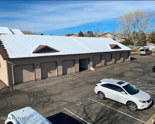 a white house covered with tall trees