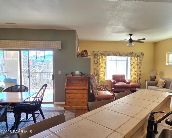a living room with furniture a large window and a table