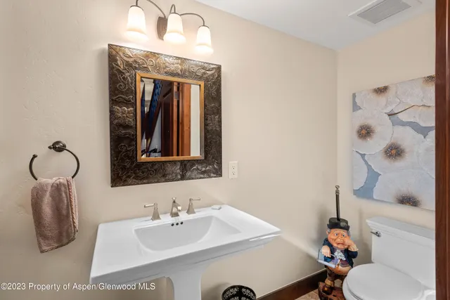 a bathroom with a sink vanity mirror and toilet