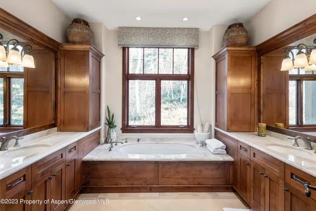 a bathroom with a tub sink and mirror