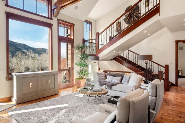 a living room with furniture a fireplace and a large window