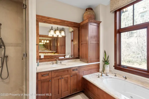 a bathroom with a double vanity sink window and mirror