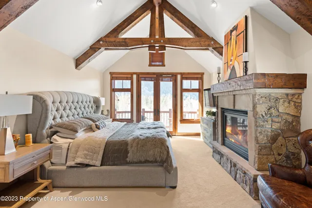 a spacious bedroom with a bed a dresser and windows