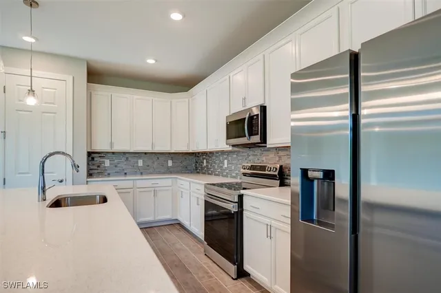 a kitchen with stainless steel appliances granite countertop a refrigerator a stove top oven a sink and dishwasher