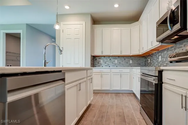 a kitchen with granite countertop a sink cabinets stainless steel appliances and a counter space