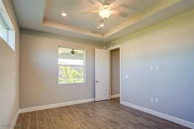 an empty room with windows and fan