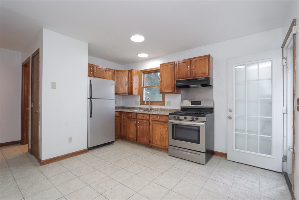 3-5 Angelo Street Springfield, MA 01119 - Photo 5 of 33 a kitchen with stainless steel appliances granite countertop a refrigerator and a stove top oven