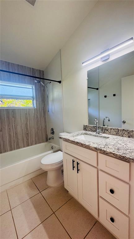 1613 Winter Green Boulevard Winter Park, FL 32792 - Photo 12 of 22 a bathroom with a granite countertop sink toilet a mirror and bathtub