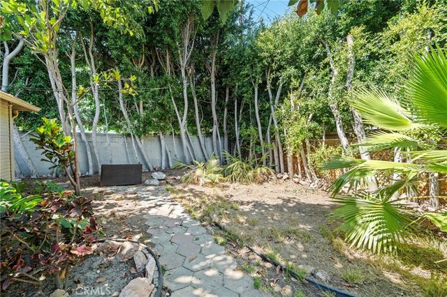 a backyard of a house with lots of green space and wooden fence