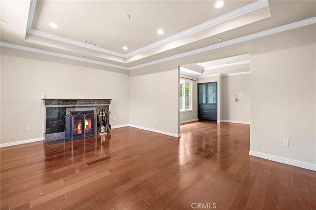a view of a livingroom with wooden floor and a fireplace
