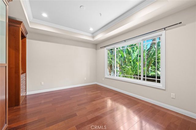 en empty room with large windows and wooden floor
