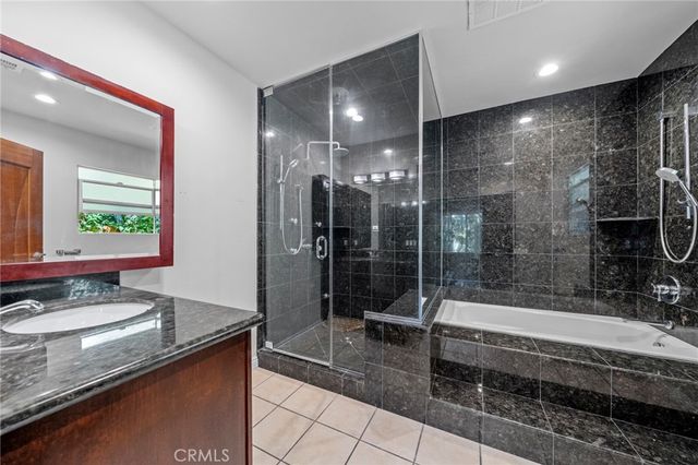 a bathroom with a granite countertop sink a toilet and shower