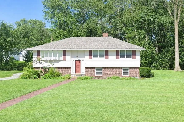 a big house with tall trees in the background