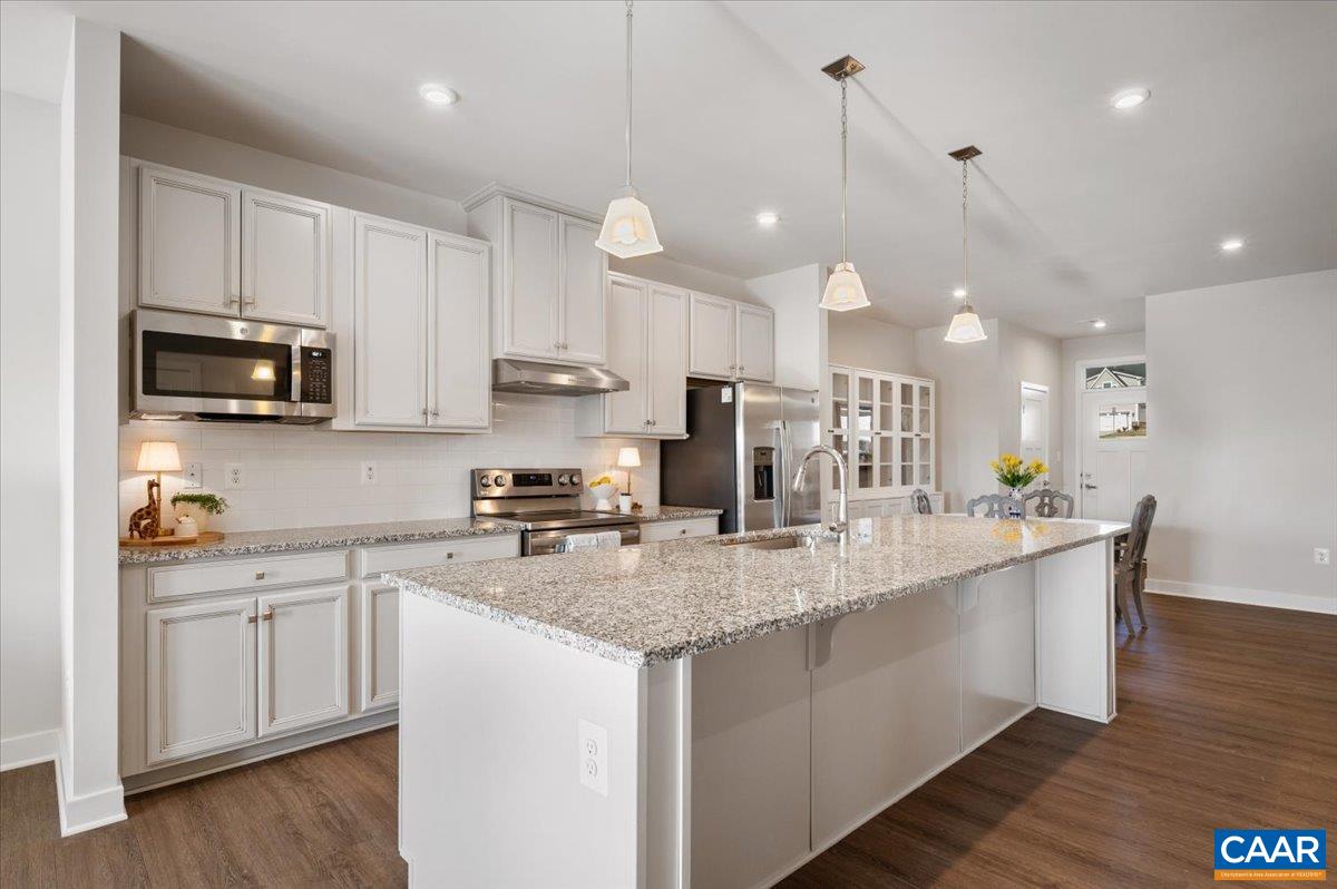 832 Swede Street Charlottesville, VA 22901 - Photo 6 of 57 a kitchen with kitchen island granite countertop a sink a counter space appliances and cabinets