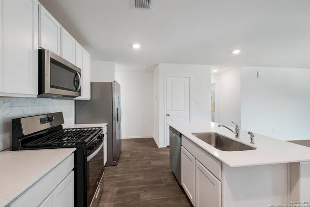 a kitchen that has a sink and a stove top oven