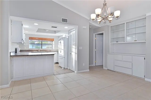 a view of a kitchen with granite countertop cabinets and chandelier