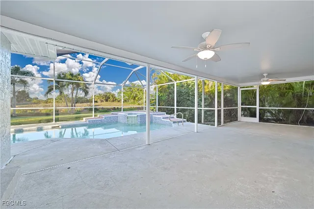 a view of an empty room with a ceiling fan and window