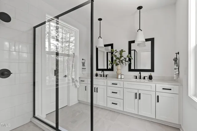 a bathroom with a double vanity sink mirror and shower