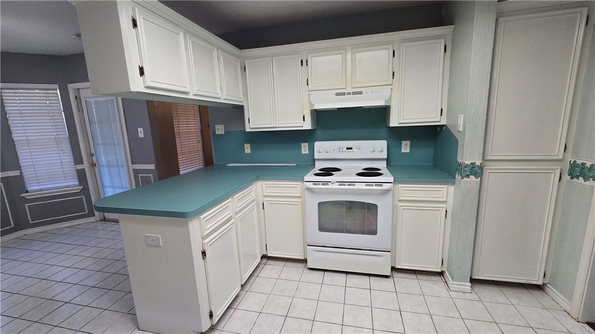 5026 Rasputin Court Corpus Christi, TX 78413 - Photo 13 of 40 a kitchen with white cabinets and white appliances
