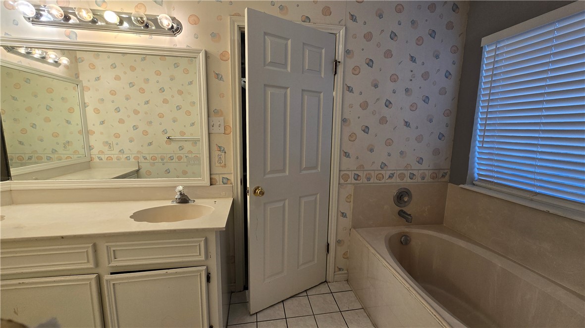 5026 Rasputin Court Corpus Christi, TX 78413 - Photo 26 of 40 a bathroom with a tub a sink and a shower