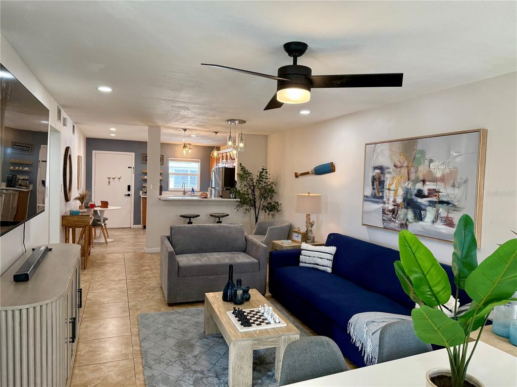 a living room with furniture potted plant and a large mirror