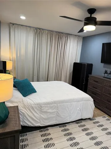 a bedroom with a bed and wooden floor