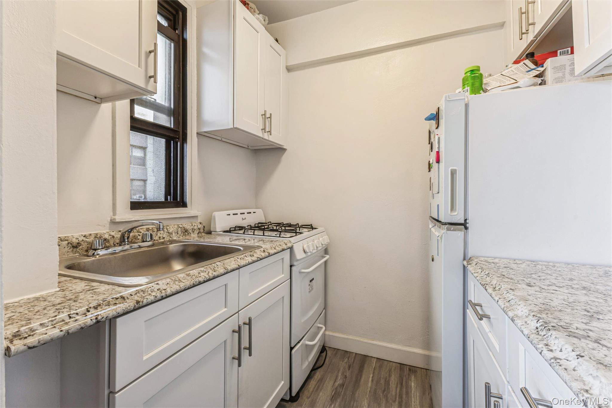 98-19 64th Avenue, Unit 3D Queens, NY 11374 - Photo 11 of 13 a kitchen with a sink and a refrigerator