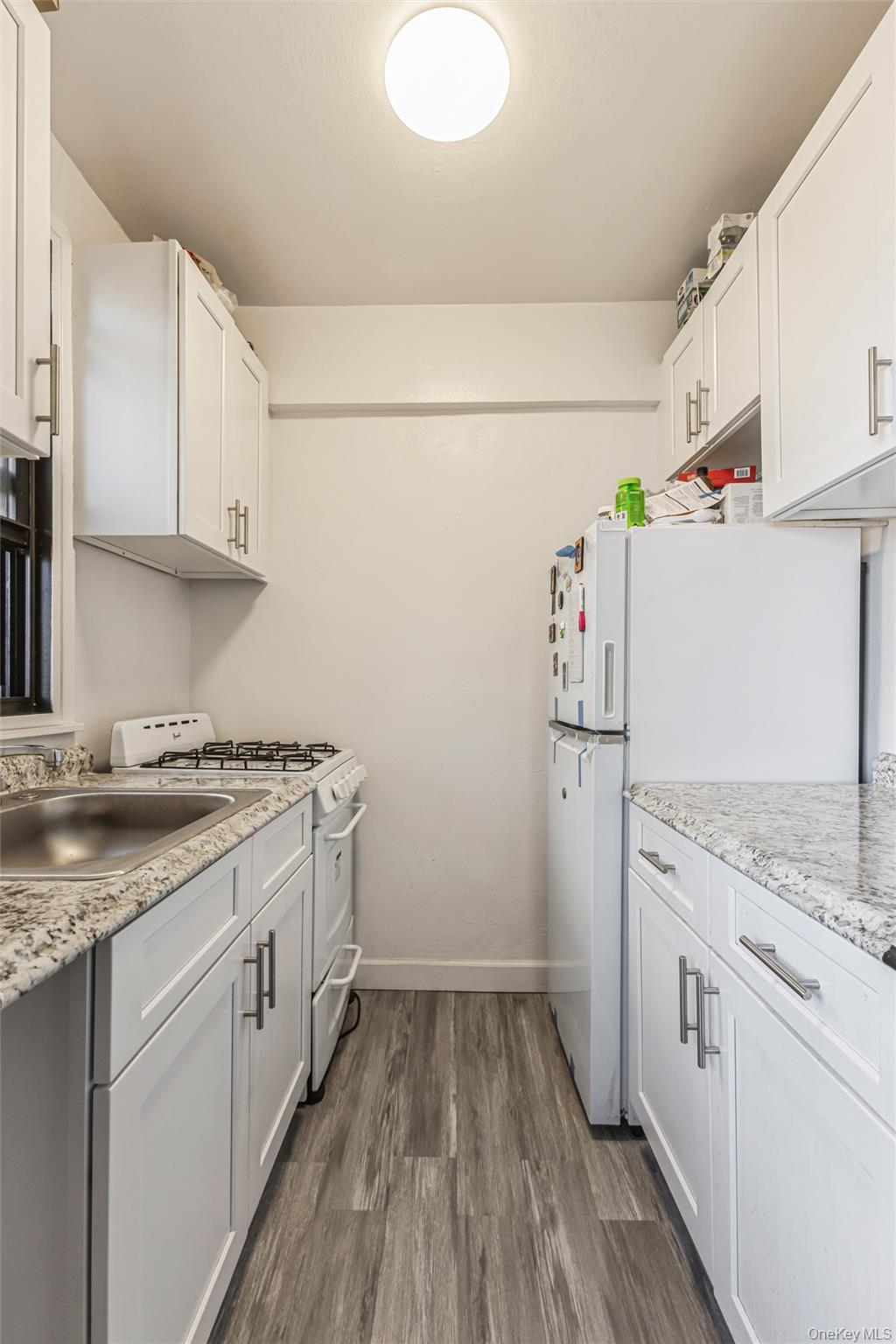 98-19 64th Avenue, Unit 3D Queens, NY 11374 - Photo 12 of 13 a kitchen with a stove a refrigerator and a sink