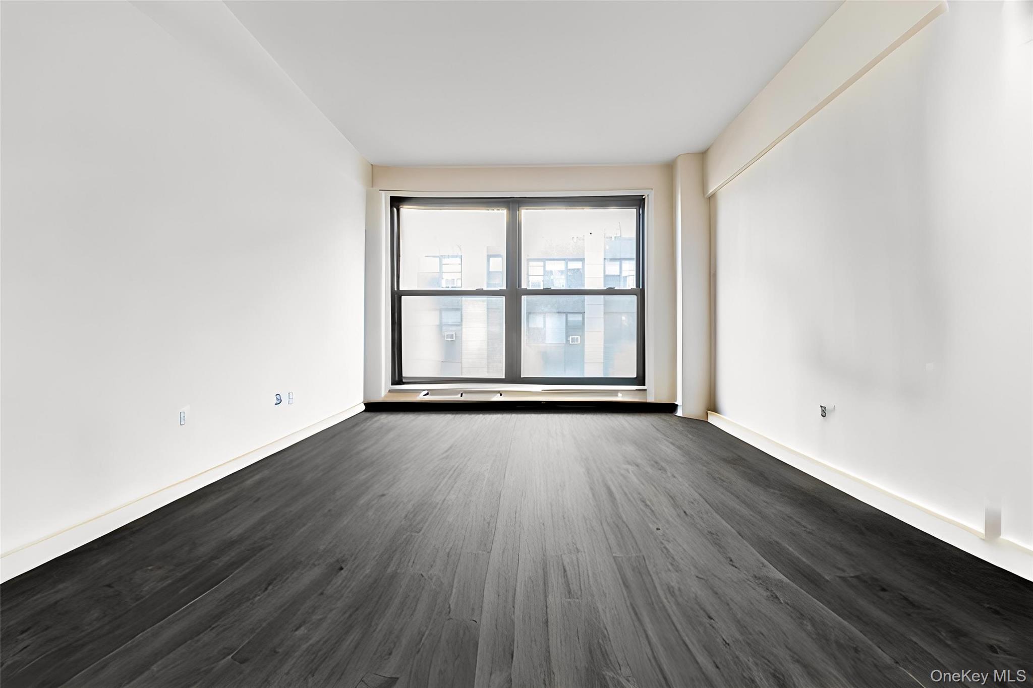 98-19 64th Avenue, Unit 3D Queens, NY 11374 - Photo 6 of 13 an empty room with wooden floor and windows