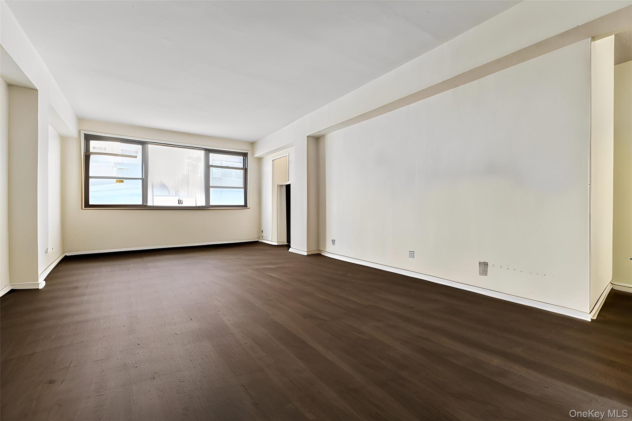 98-19 64th Avenue, Unit 3D Queens, NY 11374 - Photo 8 of 13 an empty room with wooden floor and windows