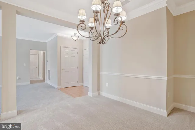 a view of a dining room with furniture a chandelier and wooden floor