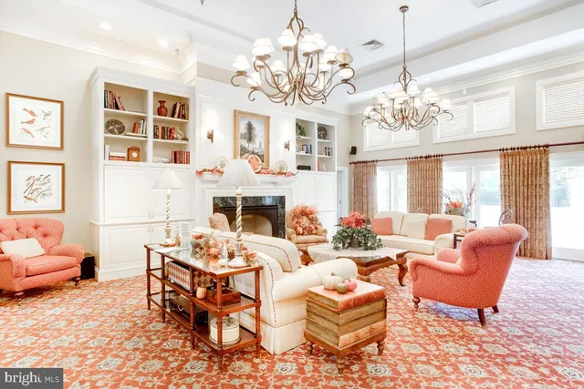 a living room with furniture a chandelier and a fireplace